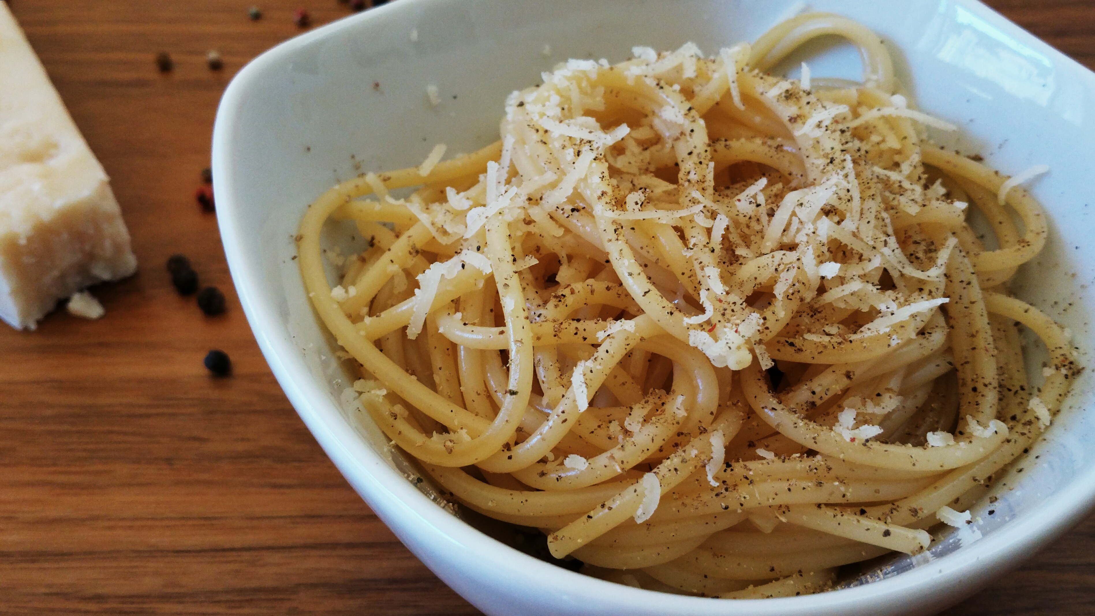 Cacio e pepe with grated cheese and black pepper; a photographed serving suggestion.