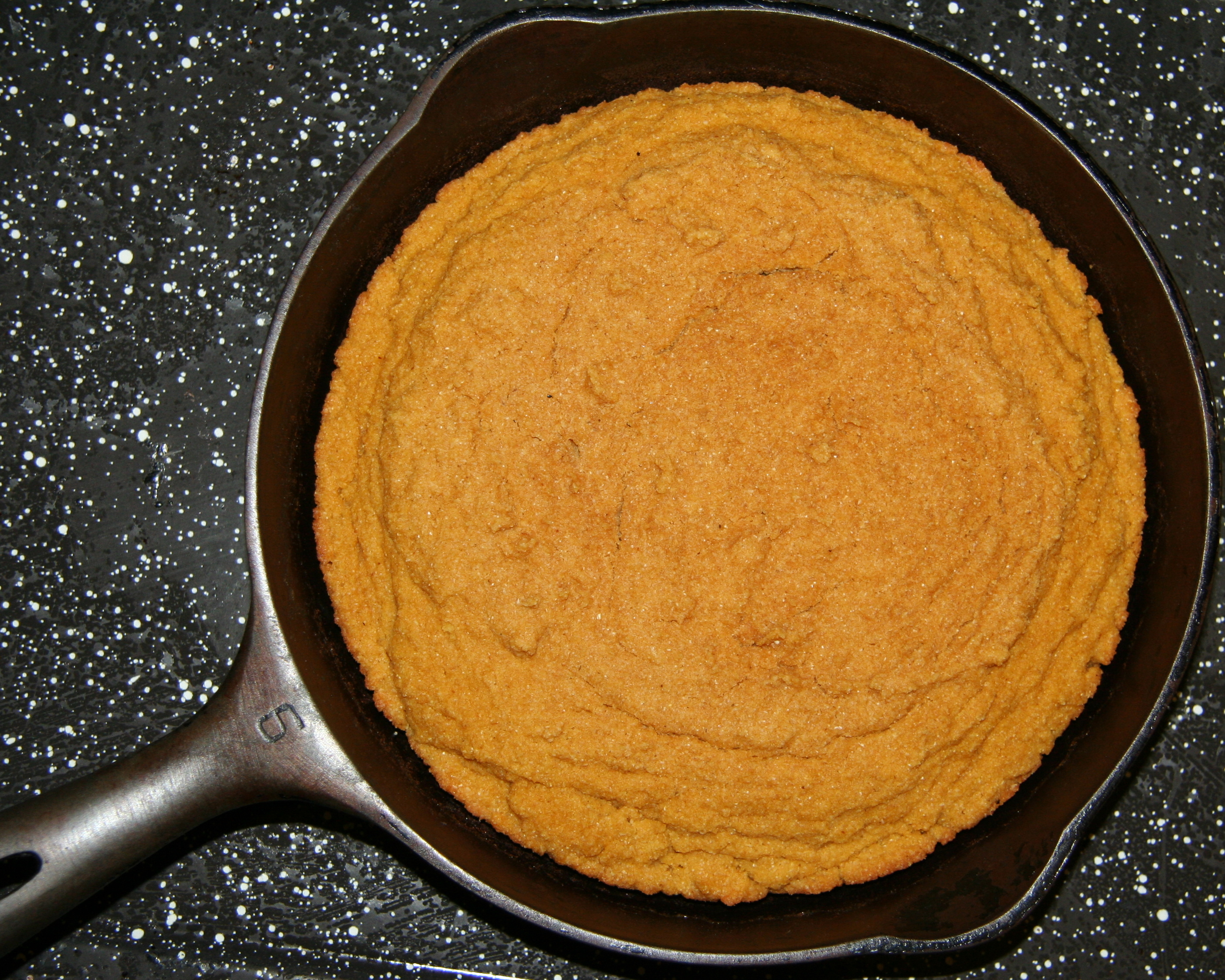 Homemade cornbread baked in a cast iron skillet.