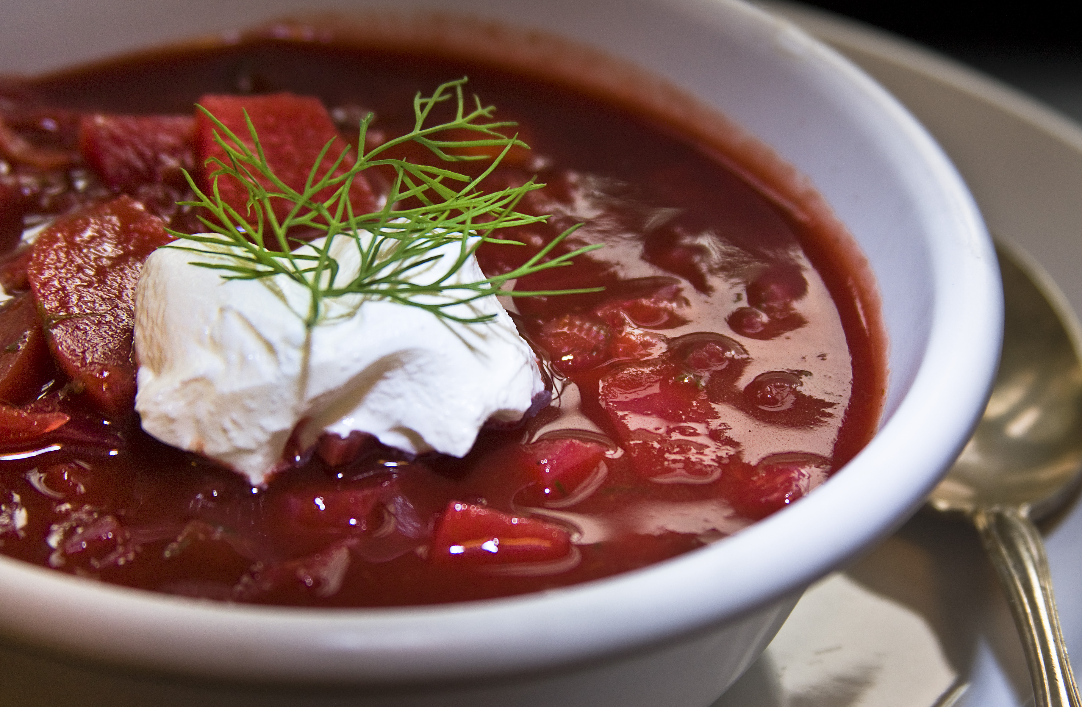 Red borscht served with sour cream; a serving suggestion.